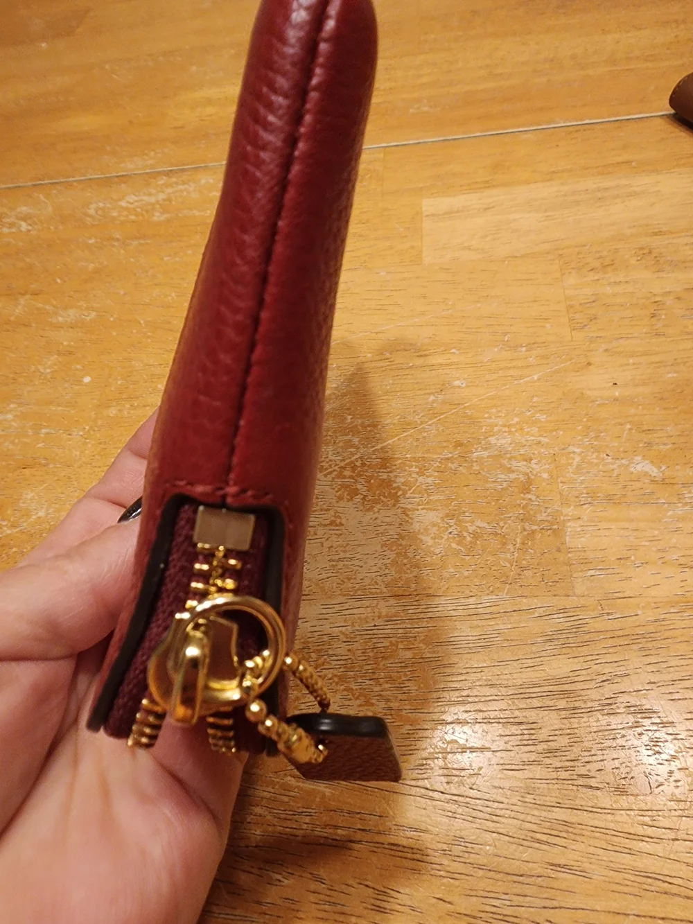 red polished pebble leather Coach wristlet, featuring gold-tone hardware